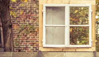 A white four-pane window frame in a brick building